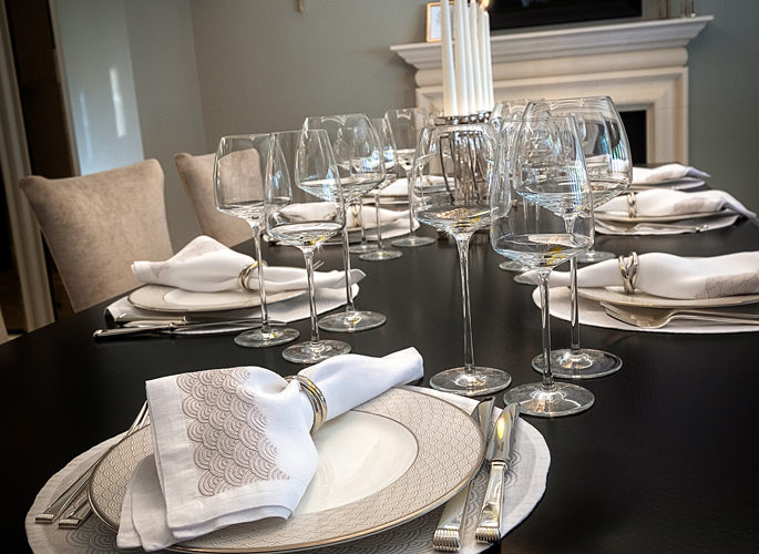 a dining table with luxury porcelain, crystal and silver
