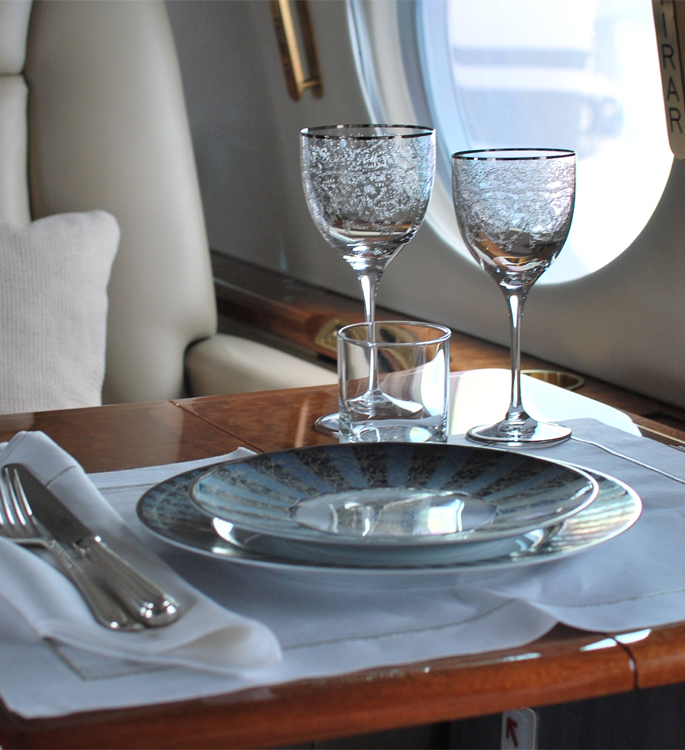 a private aircraft dining table by the window with luxury tableware