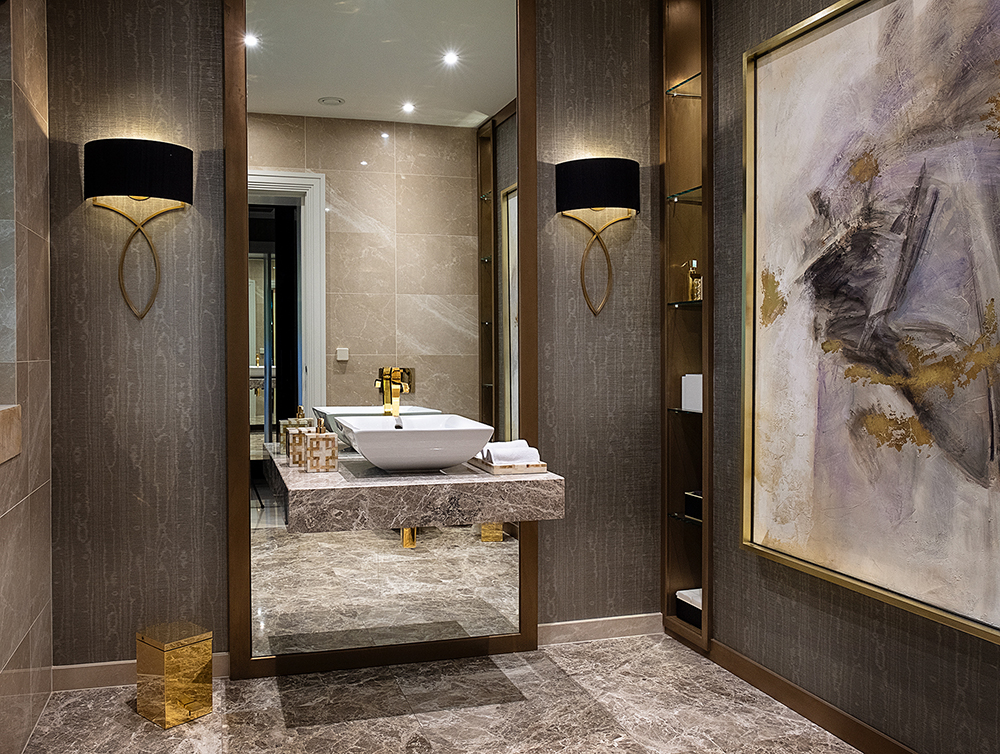 a luxury bathroom with marble floors and gold metallic detail on the furnishings and accessories