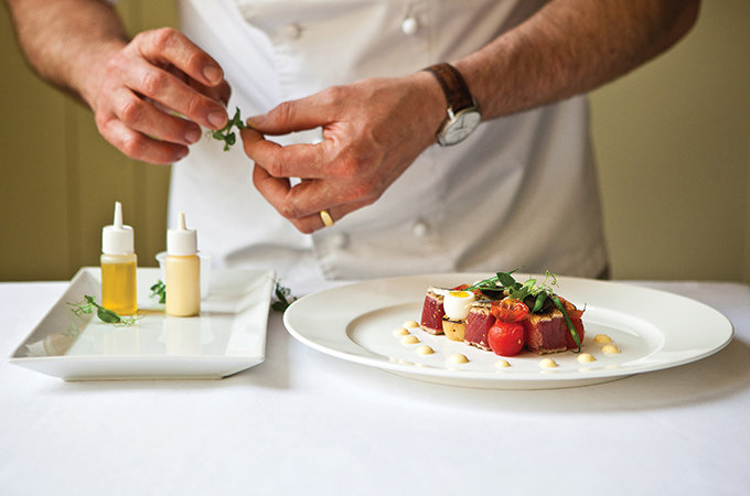 a man cooking and preparing gourmet food