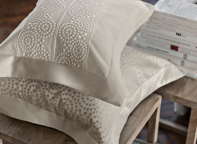 two ivory pillows with beaded style embroidery and silk oxford borders