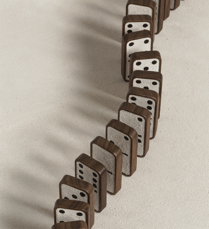 dark wooden dominoes with suede faces, lined up ready to fall