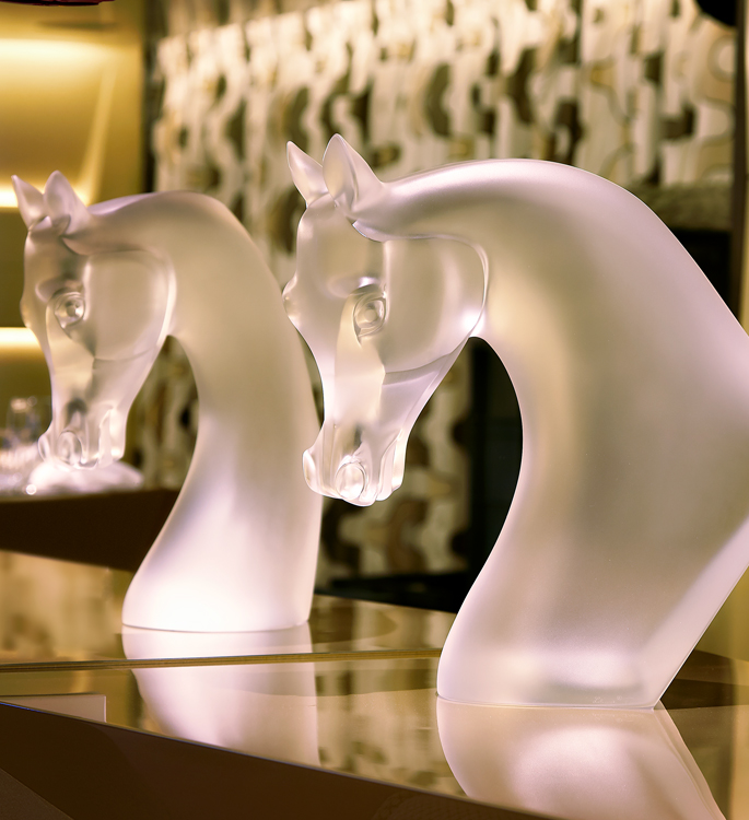 two crystal horses heads on a bar top