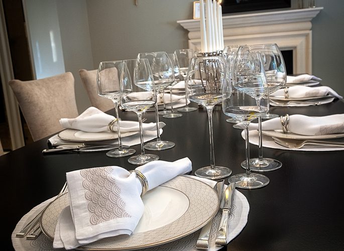 a dining table with luxury porcelain, crystal and silver