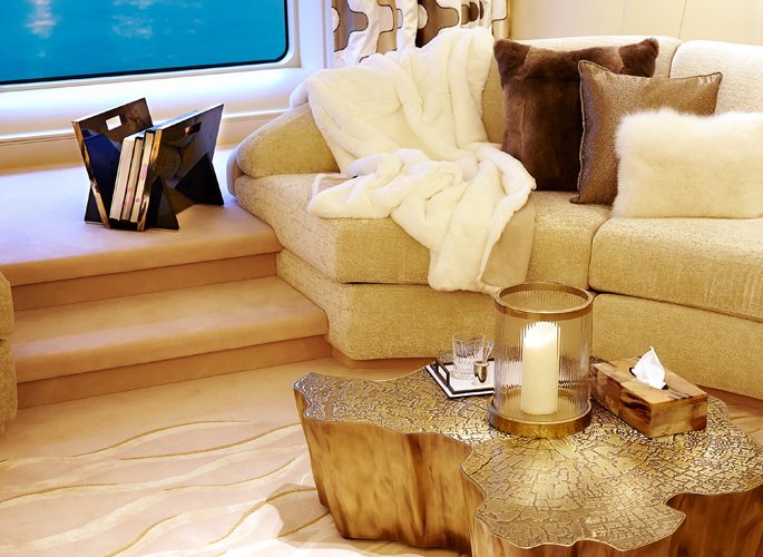 sitting room of motor yacht Aviva; a sofa with a luxury throw and accessories