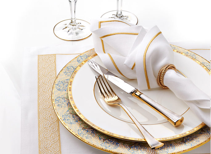 multi coloured mosaic patterned porcelain plate with table linen and cutlery