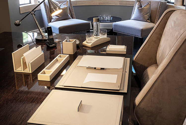 an office desk with a custom white leather stationery set and a chess set in the background