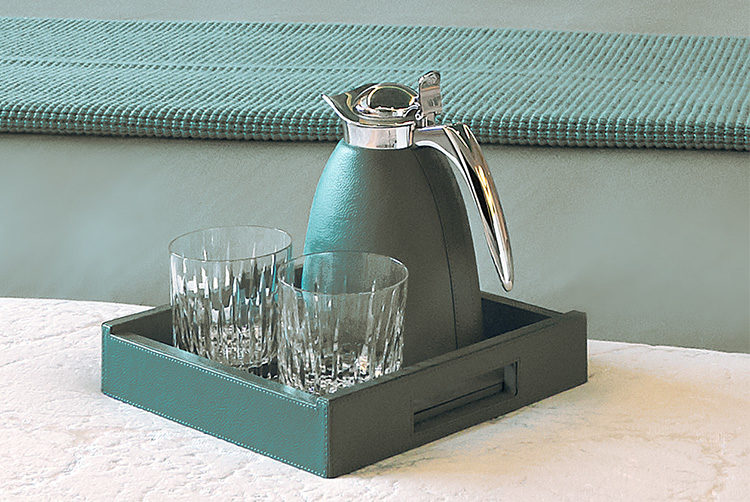 a leather skinned water jug and glass set in a striking teal colour