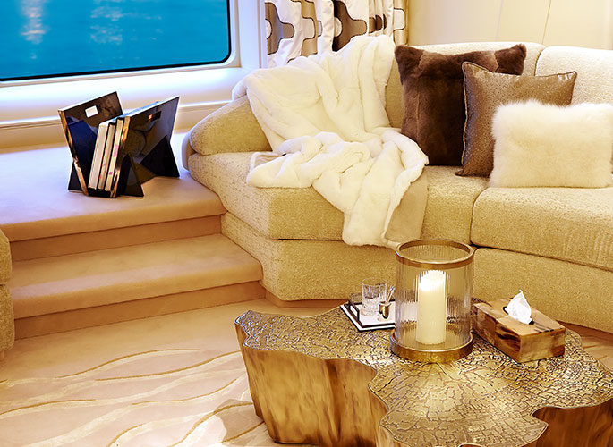 Superyacht living space with luxury cushions, fur throw over a sofa and accessories for the table