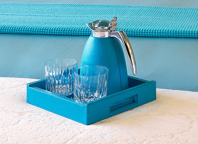 a water jug and glass set in bright blue made from leather