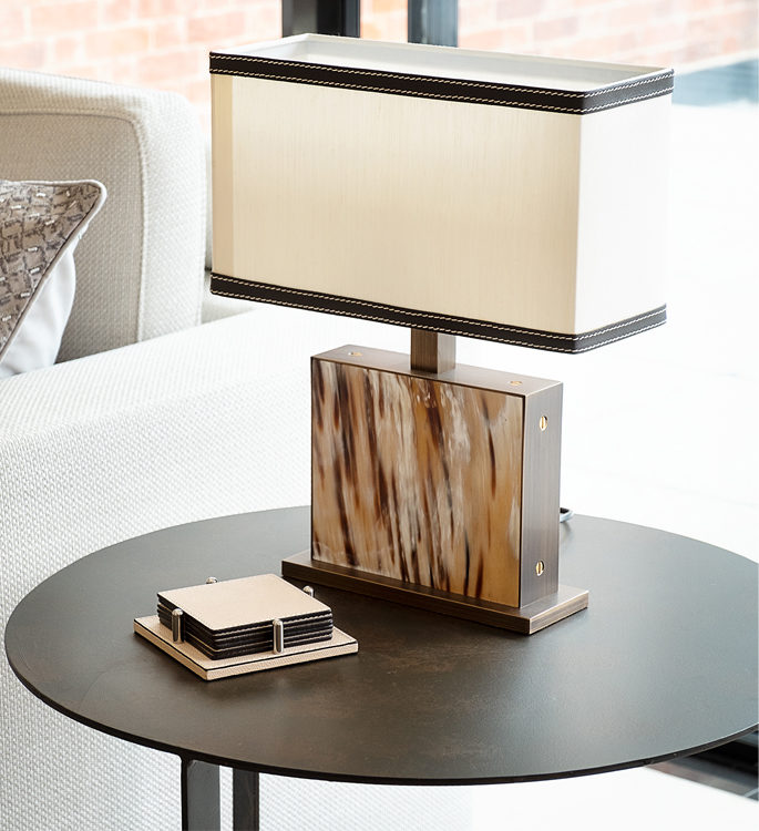 a small side table with a freestanding lamp made with natural horn materials 