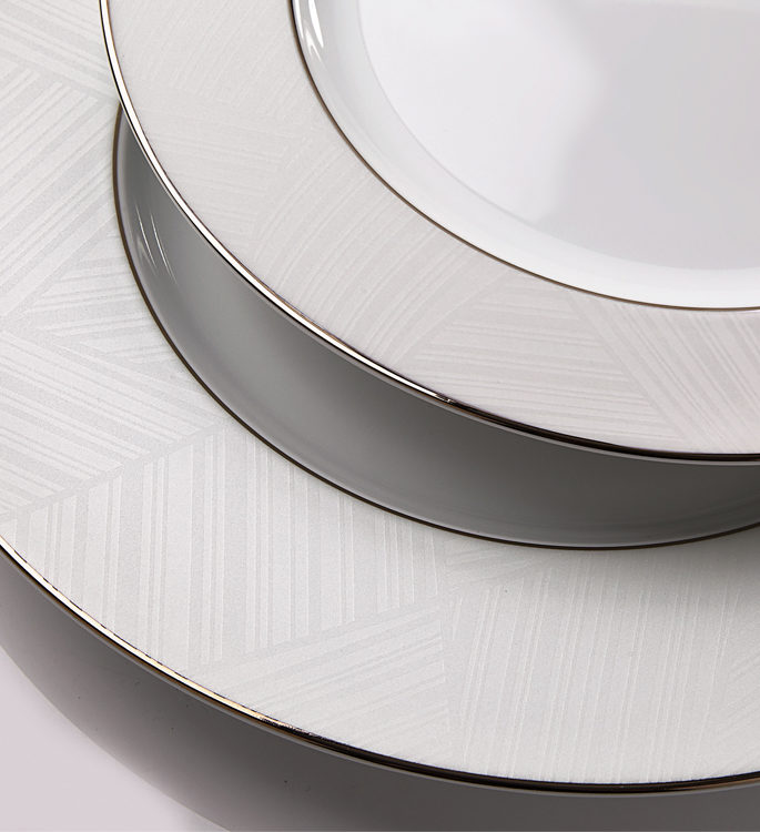 a close up of two porcelain plates with ice white line decorative details